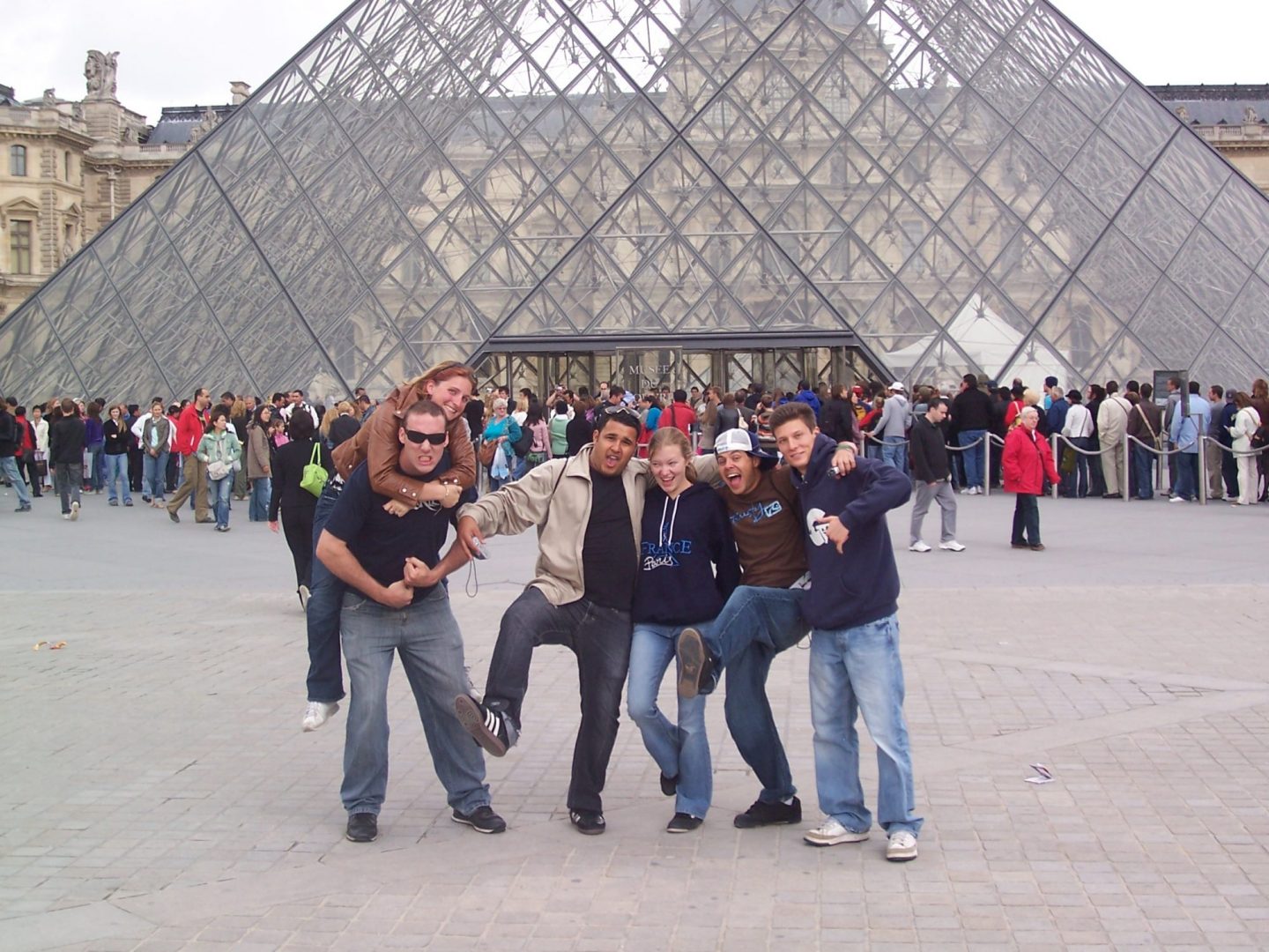 Students pose for photo in front of The Louvre in France