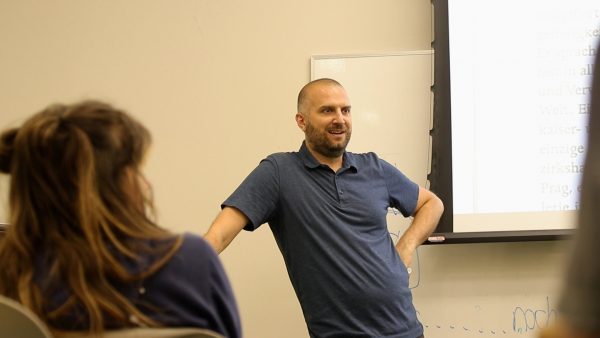 CSU German Professor Peter Erickson lecturing at the front of a classroom.
