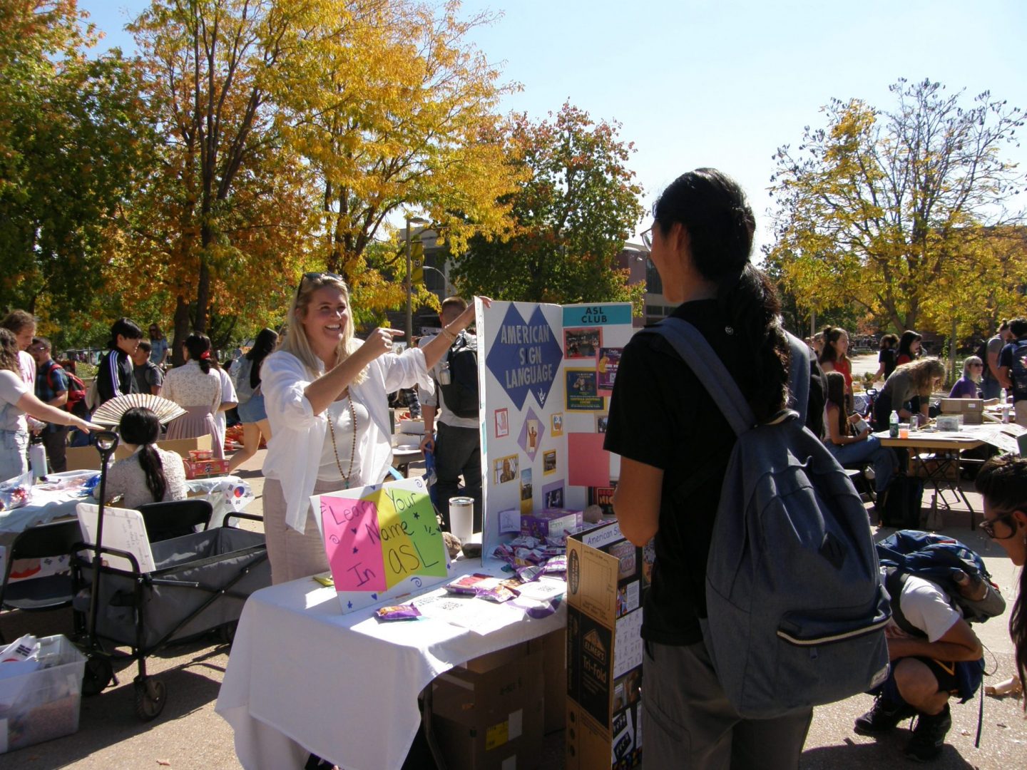 Faculty member talks about ASL club to a student at Live, Laugh, Languages event